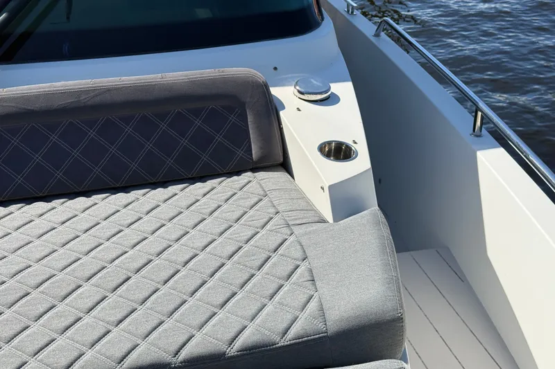 Slide: The Image of Luxurious seating on 2018 Axopar 37 Sports Cabin boat, featuring quilted upholstery and cup holder. - 32