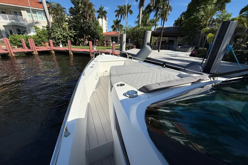 Slide: The Image of 2018 Axopar 37 Sports Cabin docked by a waterfront home, surrounded by lush greenery. - 28