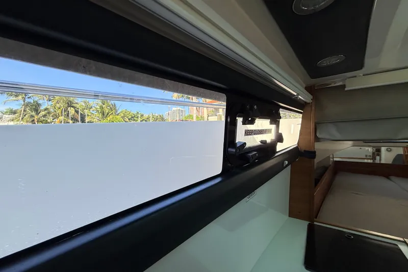 Slide: The Image of Interior view of 2018 Axopar 37 Sports Cabin, showcasing window and seating area. - 26