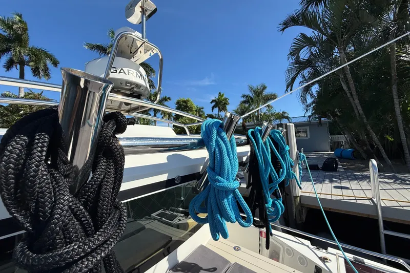 Slide: The Image of 2018 Axopar 37 Sports Cabin with ropes, docked near palm trees under clear blue sky. - 9