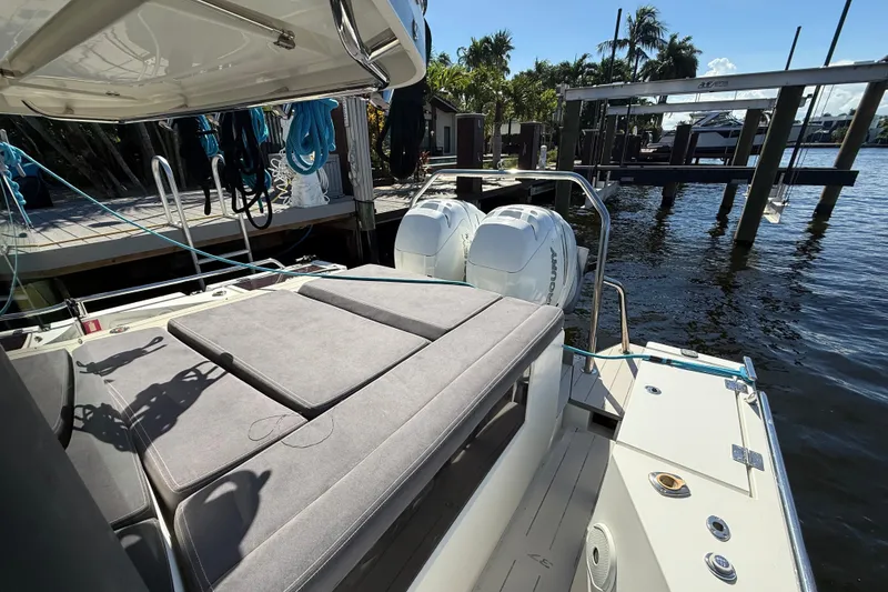 Slide: The Image of 2018 Axopar 37 Sports Cabin with twin outboard engines docked by the water. - 5