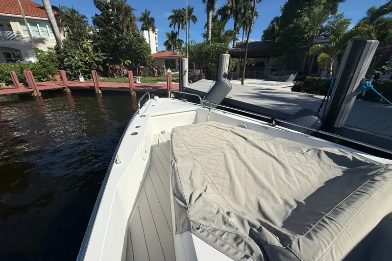 Slide: The Image of 2018 Axopar 37 Sports Cabin docked by a waterfront home with lush greenery. - 34