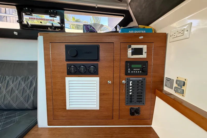 Slide: The Image of 2018 Axopar 37 Sports Cabin interior control panel with wood finish and electronic controls. - 25