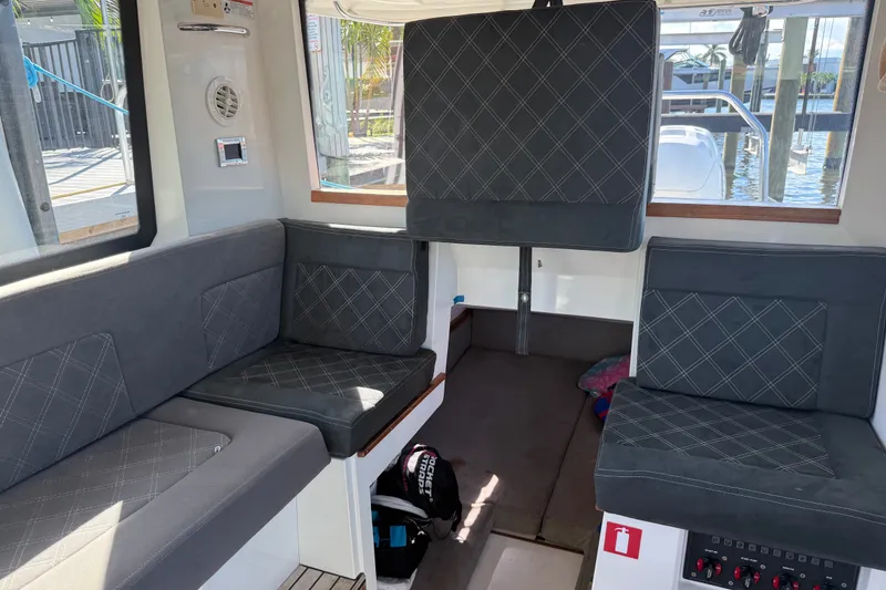 Slide: The Image of Interior of 2018 Axopar 37 Sports Cabin with gray seating and nautical decor. - 20