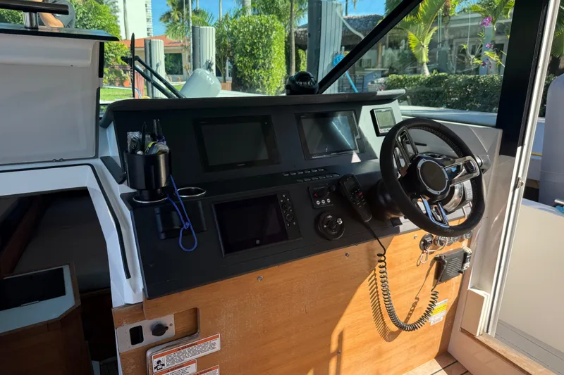 Slide: The Image of 2018 Axopar 37 Sports Cabin helm with modern navigation equipment and steering wheel. - 16