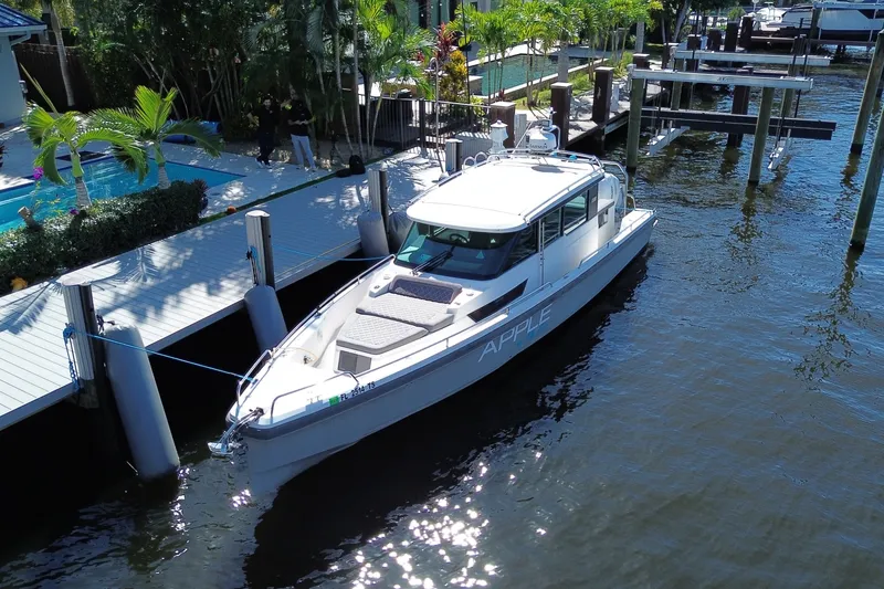 Slide: The Image of 2018 Axopar 37 Sports Cabin docked by a waterfront home. - 2