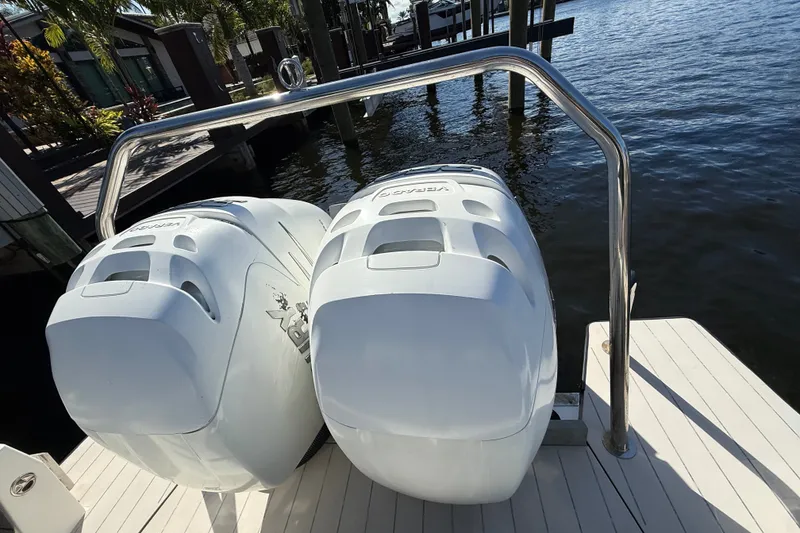 Slide: The Image of Twin outboard engines on a 2018 Axopar 37 Sports Cabin, docked by the water. - 6