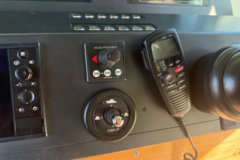 Slide: The Image of Control panel of a 2018 Axopar 37 Sports Cabin with radio and thruster controls. - 12
