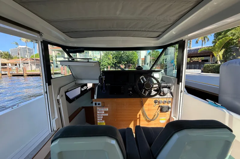 Slide: The Image of Interior view of 2018 Axopar 37 Sports Cabin, featuring helm and waterfront scenery. - 10