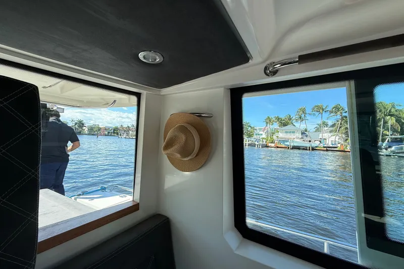 Slide: The Image of Interior view of 2018 Axopar 37 Sports Cabin with waterfront scenery and a hat hanging. - 21