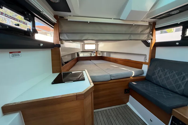 Slide: The Image of Interior of 2018 Axopar 37 Sports Cabin, featuring a cozy sleeping area and seating. - 23