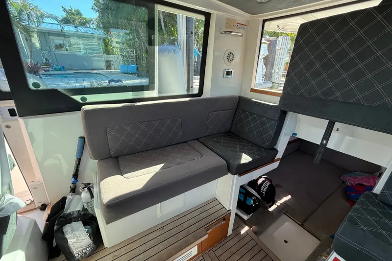 Slide: The Image of Interior of 2018 Axopar 37 Sports Cabin with cushioned seating and wooden flooring. - 18