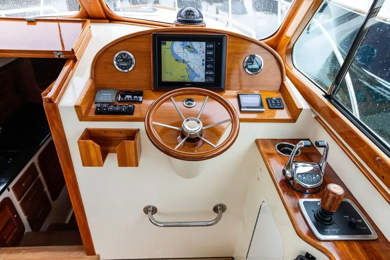 Slide: The Image of Helm of 2013 Hinckley Talaria 34 with wooden accents and navigation equipment. - 23