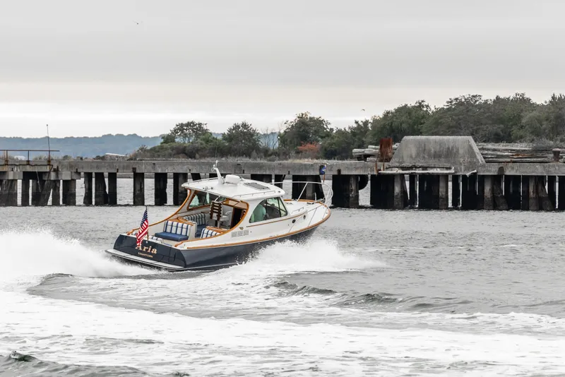 Slide: The Image of 2013 Hinckley Talaria 34 cruising near a pier on a cloudy day. - 10