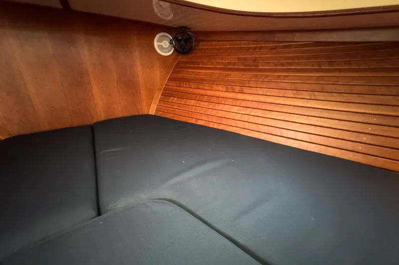 Slide: The Image of Interior cabin of 2013 Hinckley Talaria 34 with wooden paneling and black cushions. - 38