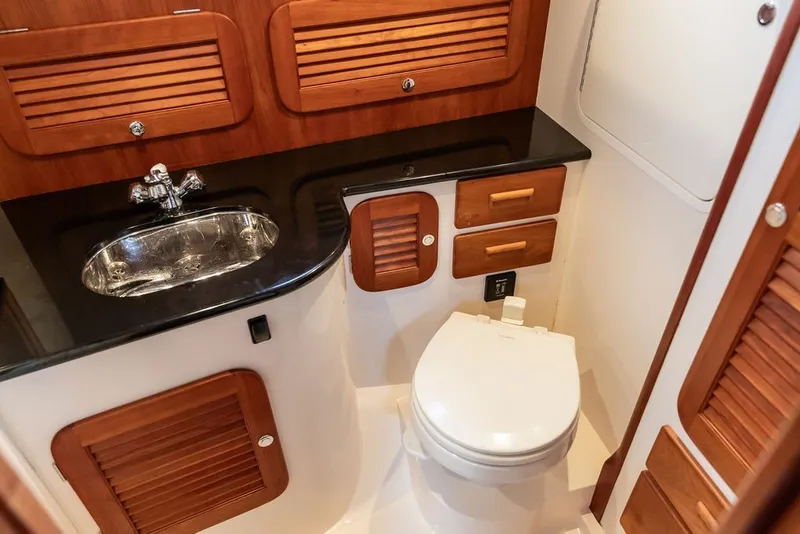 Slide: The Image of Luxurious 2013 Hinckley Talaria 34 yacht bathroom with wooden cabinetry and modern fixtures. - 31