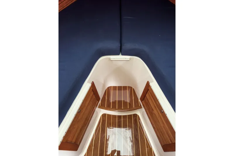 Slide: The Image of Interior view of 2013 Hinckley Talaria 34 boat with wooden flooring and blue cushions. - 35
