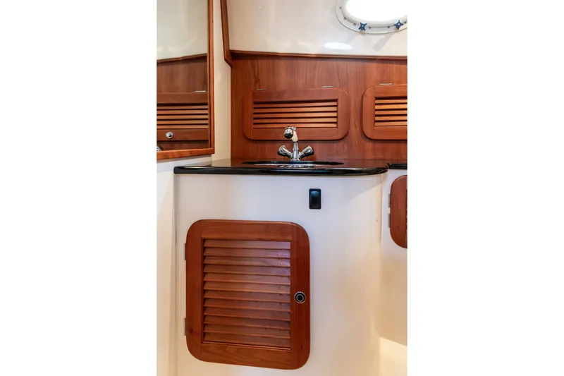 Slide: The Image of Hinckley Talaria 34 (2013) yacht interior with wooden cabinetry and sleek sink design. - 33