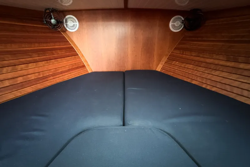 Slide: The Image of Interior cabin of 2013 Hinckley Talaria 34 with wooden paneling and black cushions. - 36