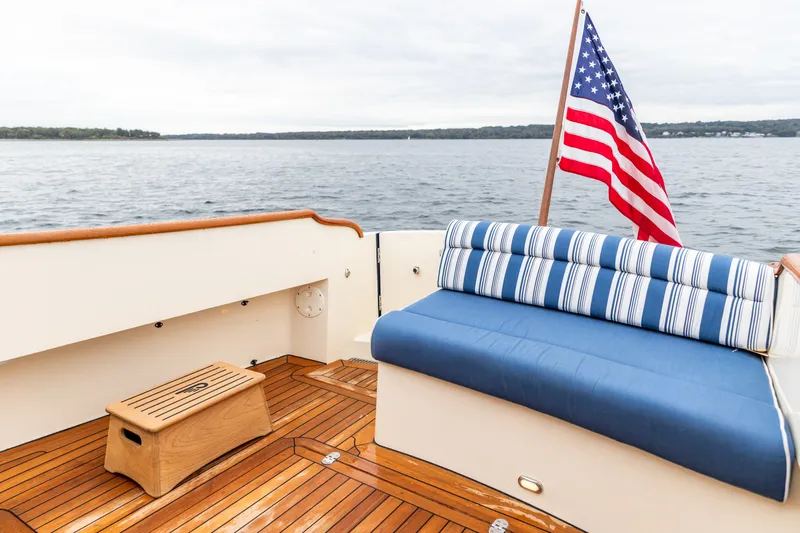 Slide: The Image of 2013 Hinckley Talaria 34 boat deck with striped seating and American flag. - 14