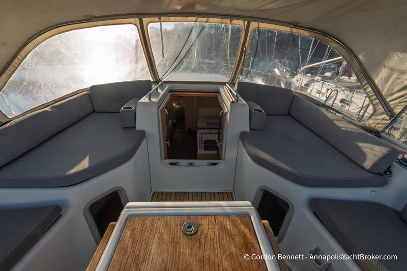 Slide: The Image of Interior view of 2020 Jeanneau 51 yacht cockpit with cushioned seating and wooden table. - 19