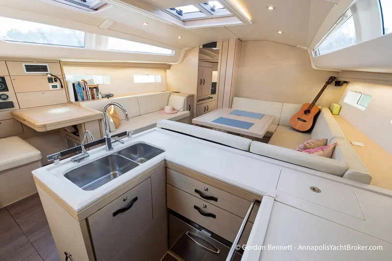 Slide: The Image of Modern interior of 2020 Jeanneau 51 yacht with kitchen, seating, and guitar. - 22