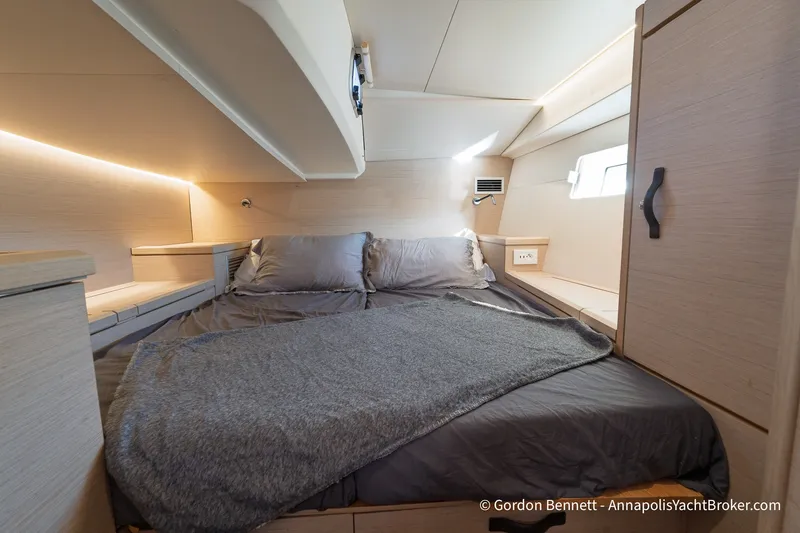 Slide: The Image of Luxurious cabin interior of a 2020 Jeanneau 51 yacht with cozy bedding and modern design. - 32