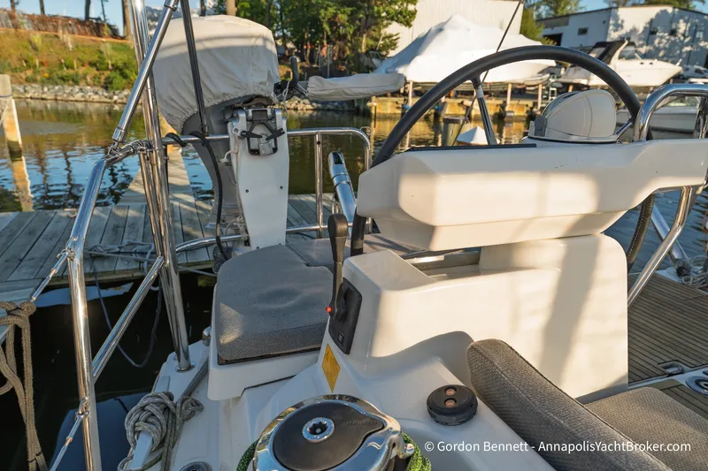 Slide: The Image of Cockpit view of 2020 Jeanneau 51 yacht at marina, showcasing steering wheel and seating. - 14