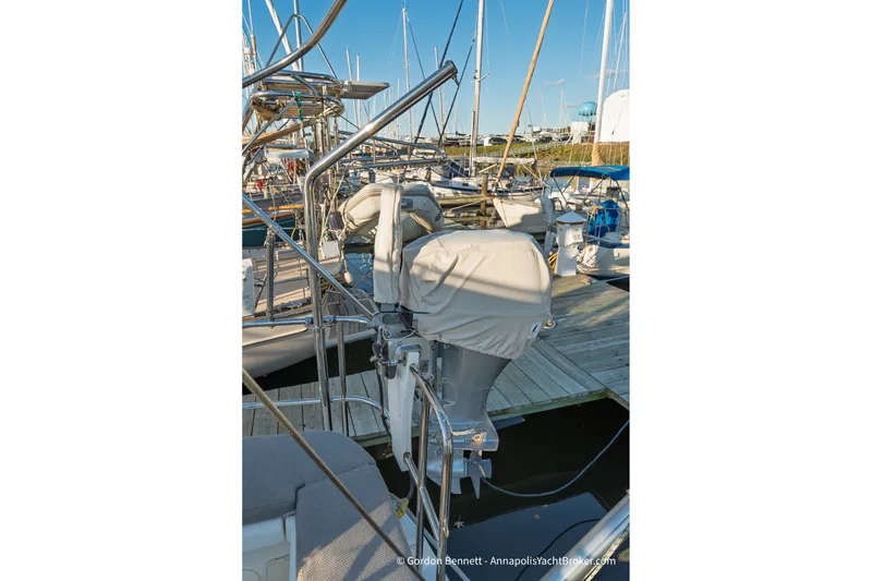 Slide: The Image of Jeanneau 51 yacht docked at marina, showcasing covered outboard motor, 2020 model. - 18