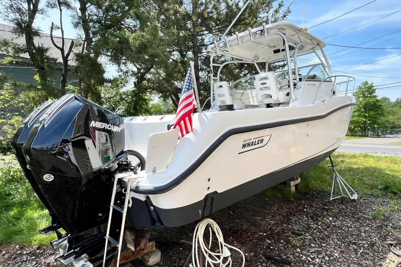 Slide: The Image of 2006 Boston Whaler 285 Conquest boat with Mercury engine, displayed outdoors. - 7