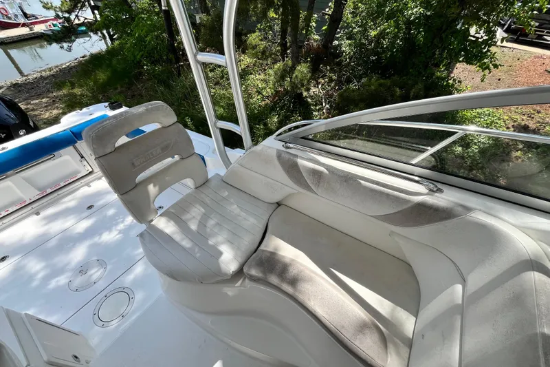 Slide: The Image of 2006 Boston Whaler 285 Conquest boat interior with seating and helm, docked near water. - 26