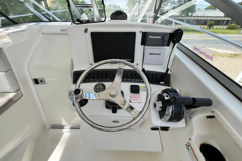 Slide: The Image of Helm of 2006 Boston Whaler 285 Conquest with steering wheel and navigation controls. - 30