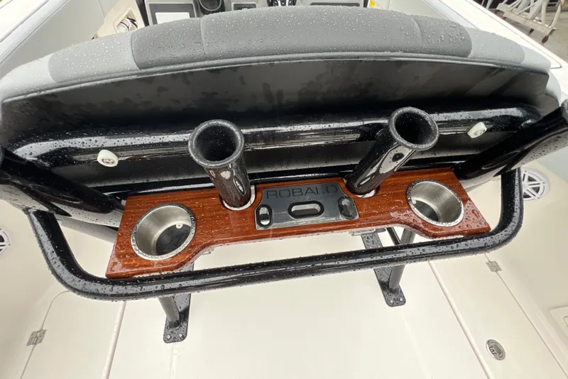 Slide: The Image of 2027 Robalo R250 Center Console boat with rod holders and cup holders on a wet deck. - 13