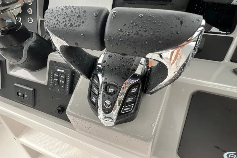 Slide: The Image of Close-up of 2027 Robalo R250 Center Console boat controls with water droplets. - 19
