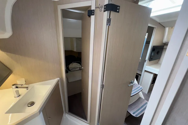 Slide: The Image of Interior of 2022 Beneteau Oceanis 40.1 yacht, featuring a compact bathroom and cabin entrance. - 43