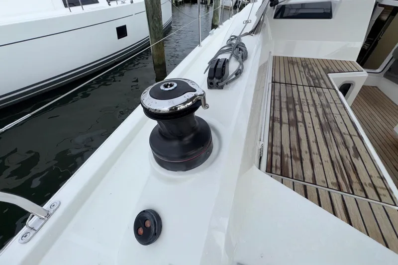 Slide: The Image of Deck view of 2022 Beneteau Oceanis 40.1 sailboat, featuring winch and teak flooring. - 14