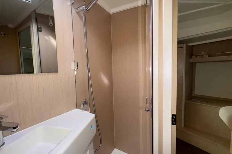 Slide: The Image of Interior of 2022 Beneteau Oceanis 40.1 yacht bathroom with modern fixtures and wood paneling. - 39
