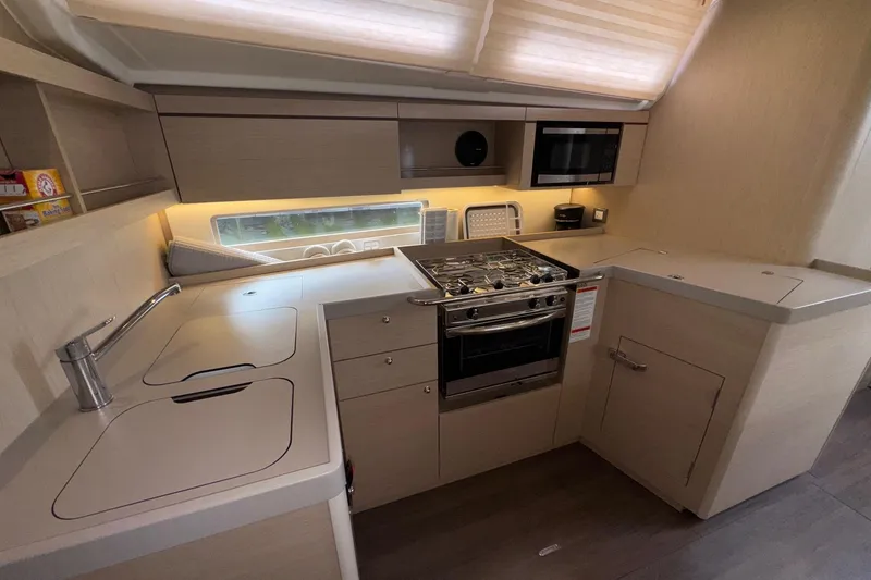 Slide: The Image of Modern kitchen in 2022 Beneteau Oceanis 40.1 yacht with stove, sink, and microwave. - 29