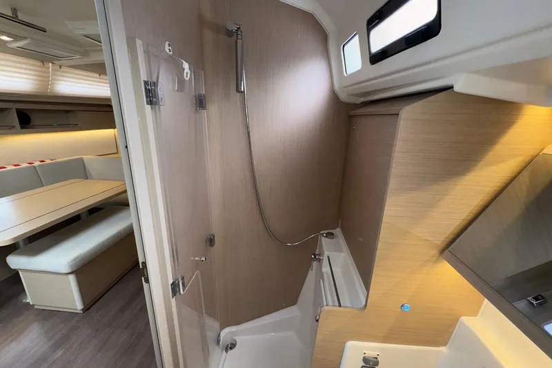 Slide: The Image of Modern interior of 2022 Beneteau Oceanis 40.1 yacht, featuring a sleek shower and dining area. - 46