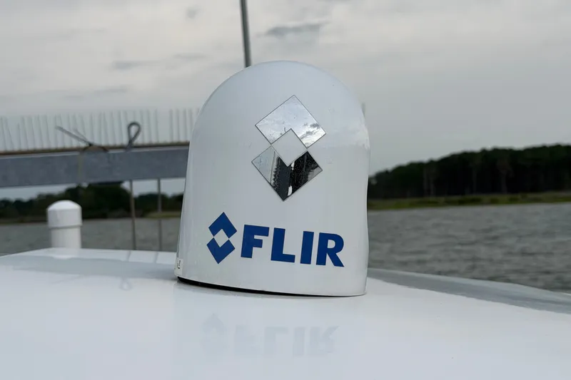 Slide: The Image of FLIR radar on 2023 Axopar 28 Cabin boat, with water and trees in the background. - 49