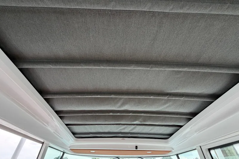 Slide: The Image of Interior ceiling of 2023 Axopar 28 Cabin boat, featuring a sleek, padded design. - 25