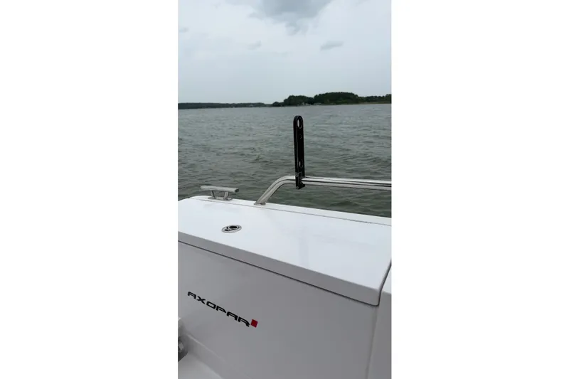 Slide: The Image of 2023 Axopar 28 Cabin boat on water, featuring sleek white design and chrome railing. - 51