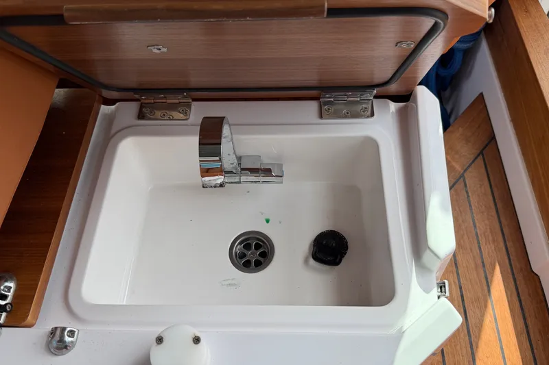 Slide: The Image of 2023 Axopar 28 Cabin sink with chrome faucet and wooden accents. - 21