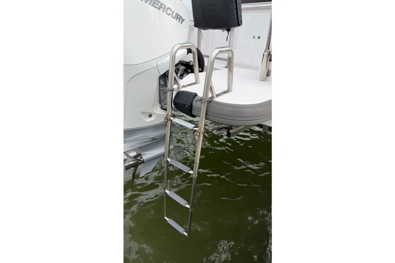 Slide: The Image of Stainless steel ladder on 2023 Axopar 28 Cabin boat, extending into water. - 55