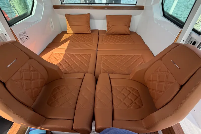 Slide: The Image of Luxurious interior of 2023 Axopar 28 Cabin with brown leather seating and cushions. - 19