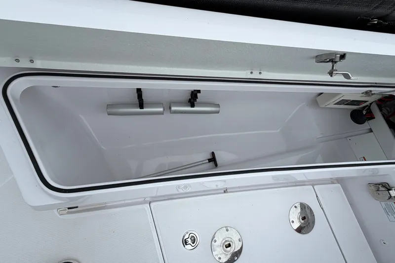 Slide: The Image of 2023 Axopar 28 Cabin storage compartment with open hatch and visible hardware. - 35