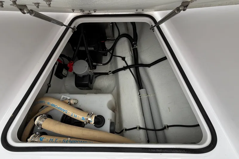 Slide: The Image of 2023 Axopar 28 Cabin engine compartment with hoses and wiring. - 32
