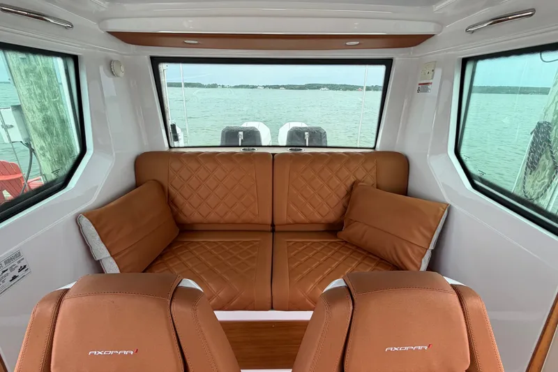 Slide: The Image of Interior of 2023 Axopar 28 Cabin with brown leather seating and panoramic windows. - 15