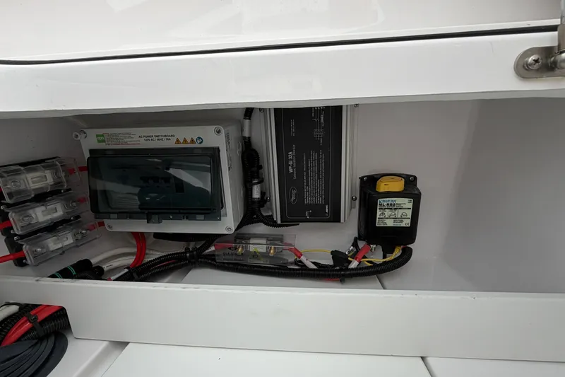 Slide: The Image of Electrical components inside 2023 Axopar 28 Cabin boat, featuring wiring and control systems. - 34