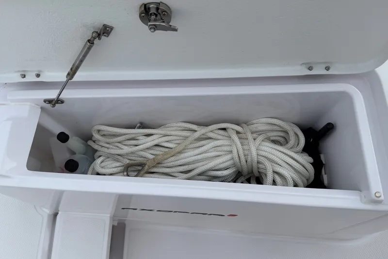 Slide: The Image of Storage compartment on 2023 Axopar 28 Cabin boat with coiled rope and accessories. - 45